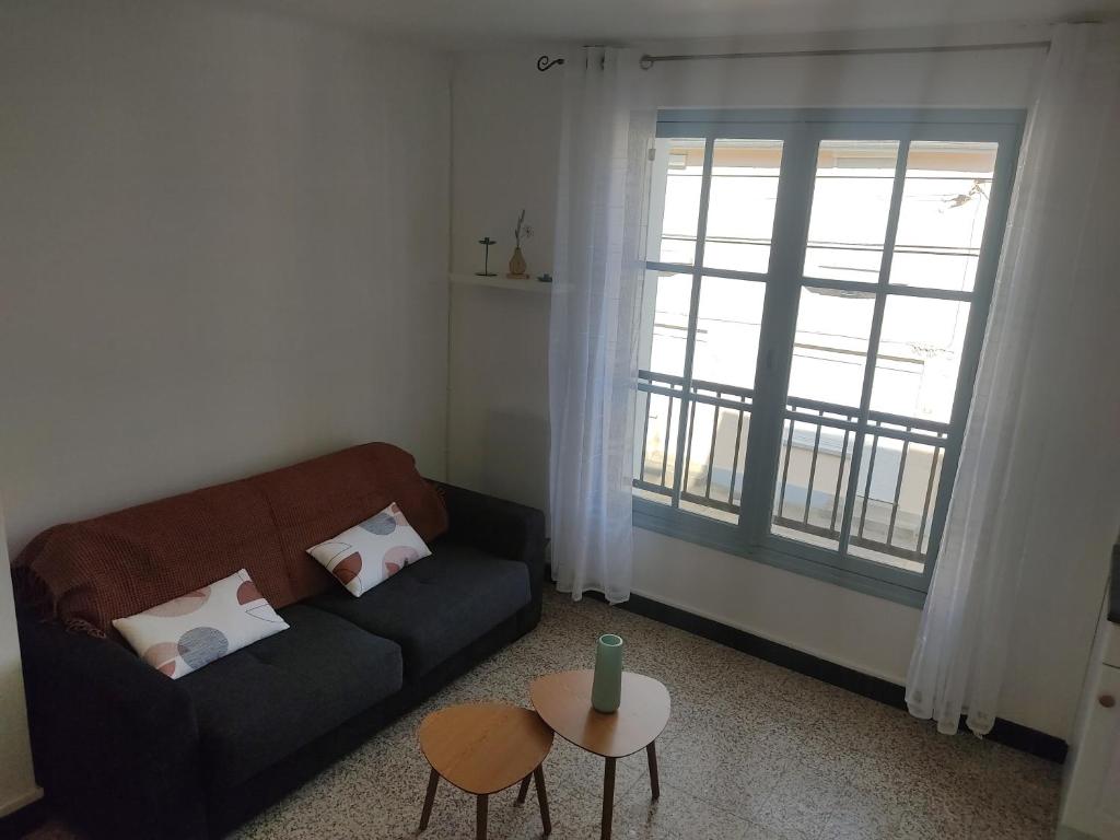 un salon avec un canapé, une table et une fenêtre dans l'établissement Hespérides, à Fort-Mahon-Plage