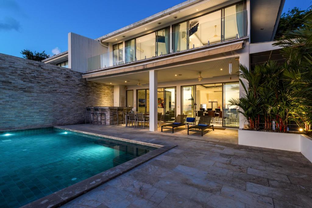 a house with a swimming pool in front of a house at Villa Oceane in Thong Son Beach