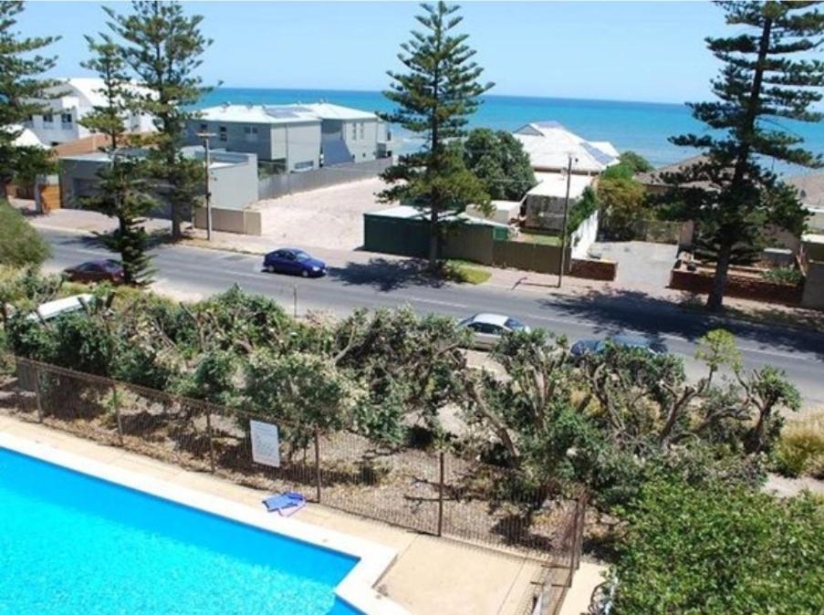 an aerial view of a swimming pool and a parking lot at Casa Luna Beachside Apartment in Henley Beach South