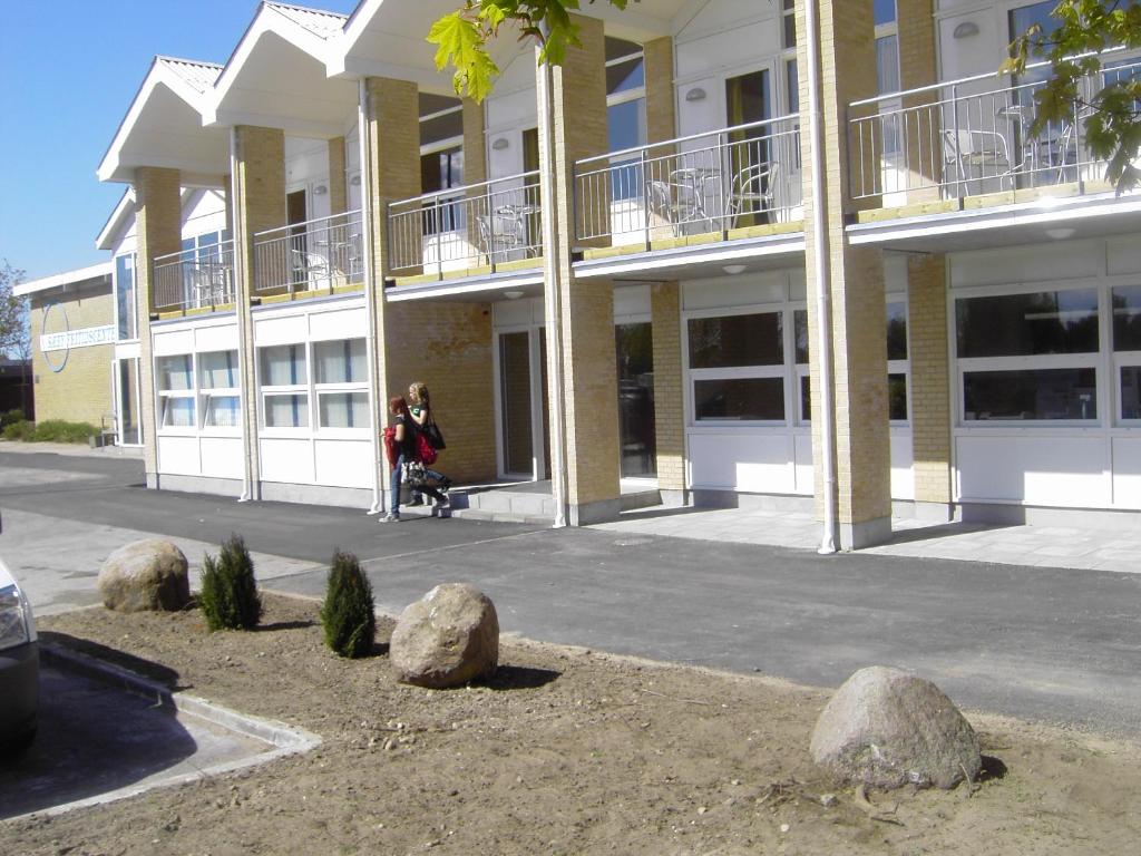 a woman standing in front of a building at Sæby Spektrum & Hostel in Sæby