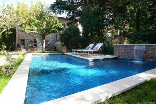 a pool with two chairs and a table in a yard at L'Abri du Poète in Besse-sur-Issole