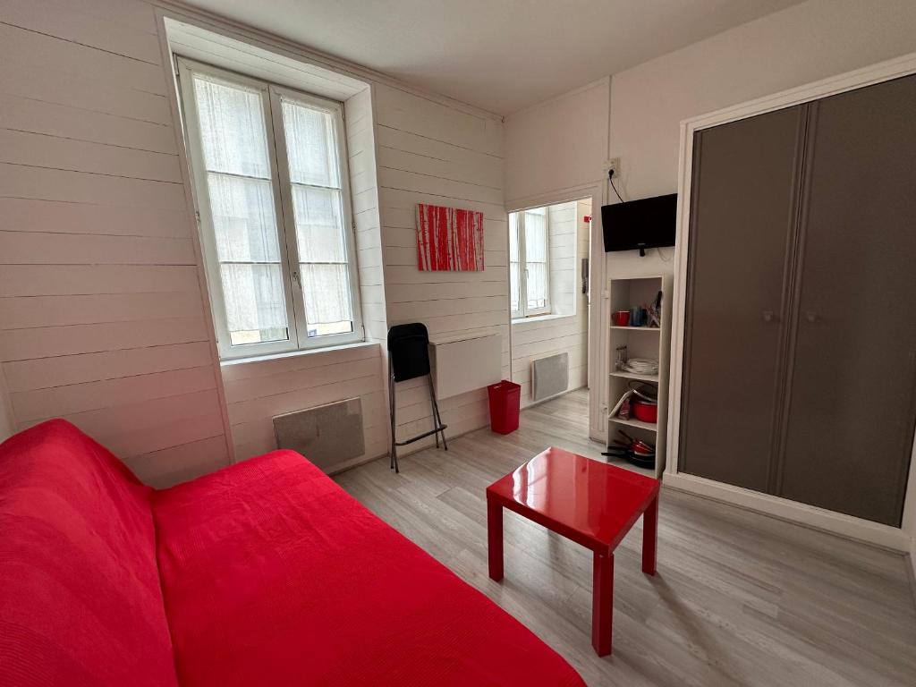 un salon avec un canapé rouge et une table dans l'établissement Charmant Studio Carmes 3 - CDDT, à La Rochelle