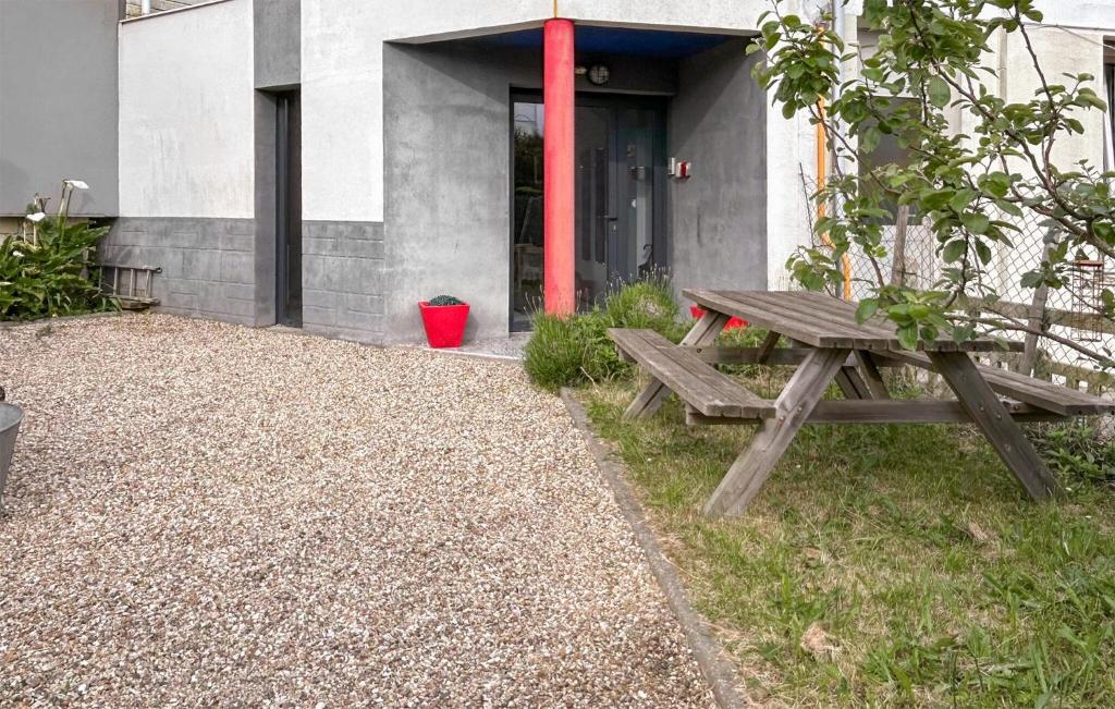 - une table de pique-nique en bois installée devant un bâtiment dans l'établissement Beautiful Apartment In Sainte-Adresse, à Sainte-Adresse