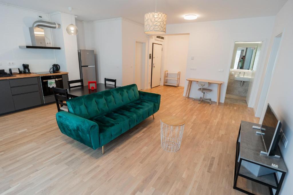 un soggiorno con un divano verde e un tavolo di Lagoon Park Apartments with Beach View a Bucarest