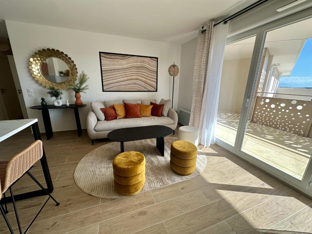 un salon avec un canapé et une table dans l'établissement Appartement neuf proche plage, à Sète