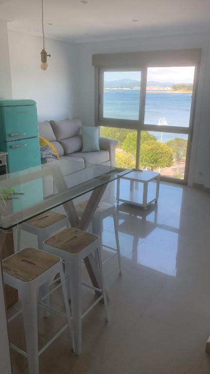 a living room with a glass table and a couch at Luz de Mar in O Grove