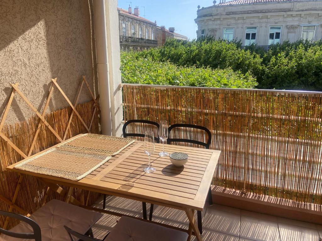 une table et des chaises en bois sur un balcon dans l'établissement Charmant Appartement Central Terrasse proche gare, à Sète