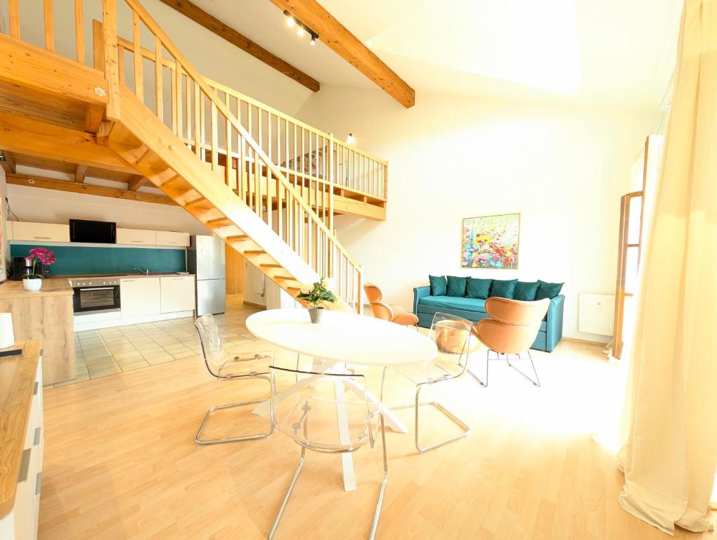 a living room with a staircase and a table and chairs at Galeriewohnung bei Wasserburg am Inn in Soyen