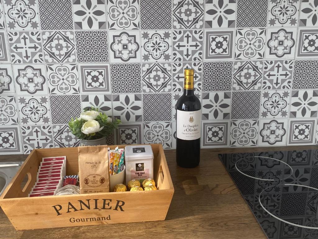 - une bouteille de vin à côté d'une boîte de nourriture dans l'établissement Appartement Cosy vue sur la cathédrale Albi, à Albi