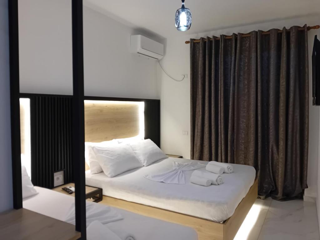 a bedroom with a bed with white sheets and pillows at Villa Allkushi in Sarandë