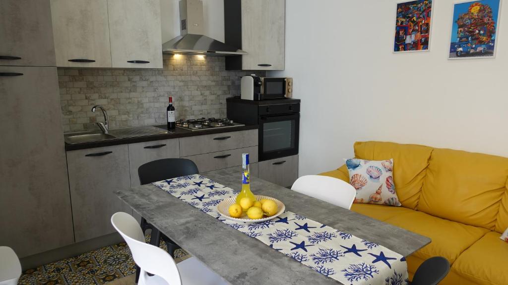kuchnia ze stołem, na którym stoi miska z owocami w obiekcie Stella di Mare w mieście Balestrate