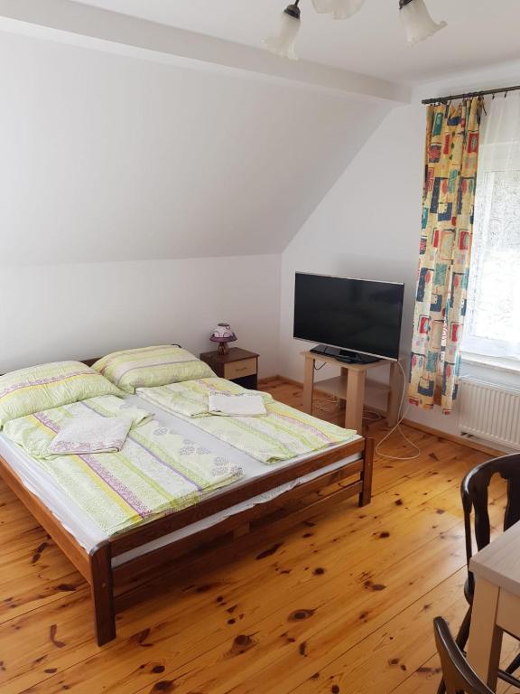 a bedroom with a bed and a flat screen tv at Pokój 4osobowy in Swornegacie
