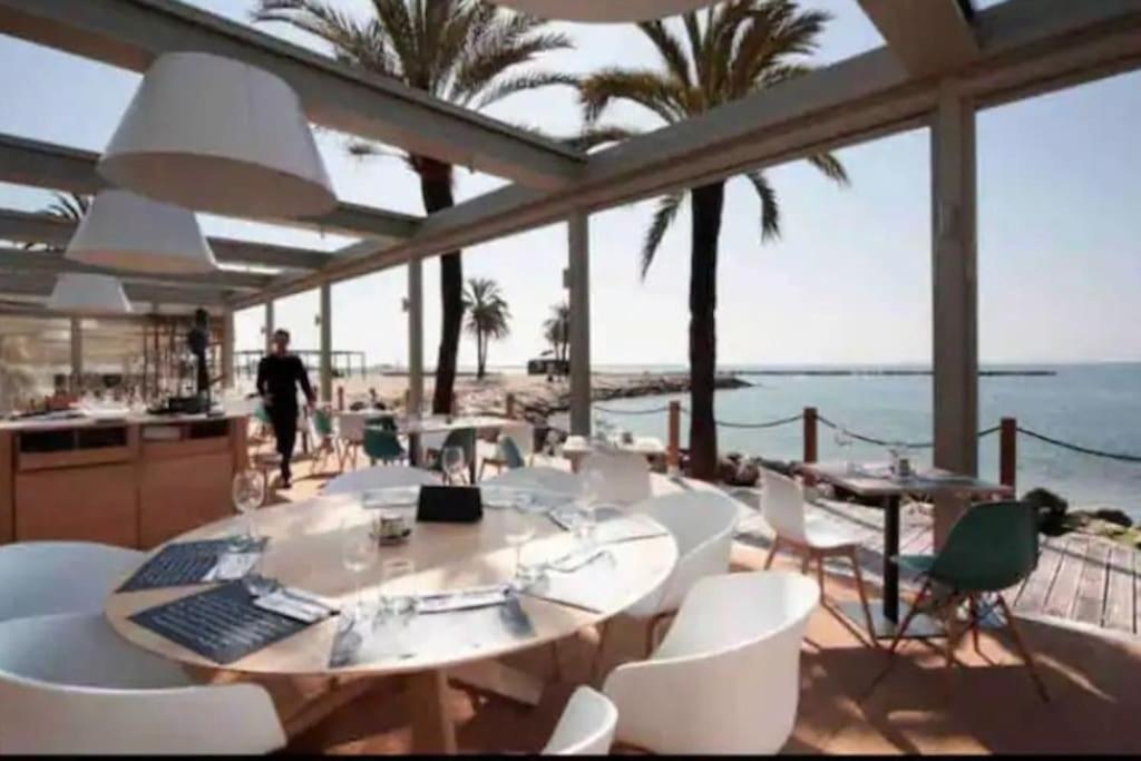 a dining room with a view of the ocean at Appartement avec piscine in Saint-Laurent-du-Var