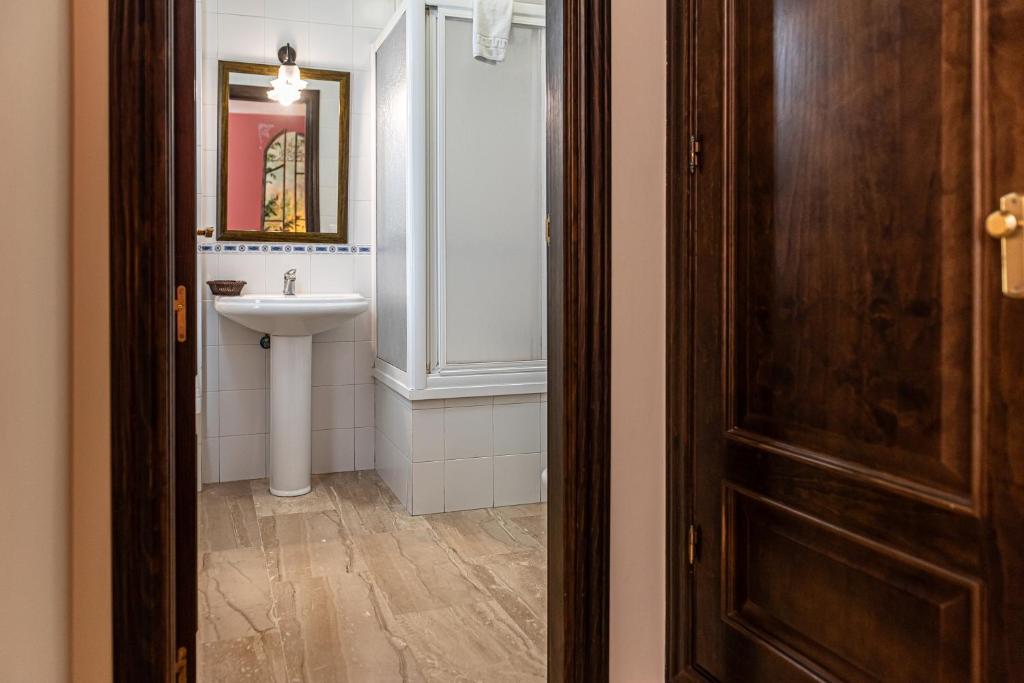 łazienka z umywalką, toaletą i drzwiami w obiekcie Hotel Las Rosas w mieście Priego de Córdoba