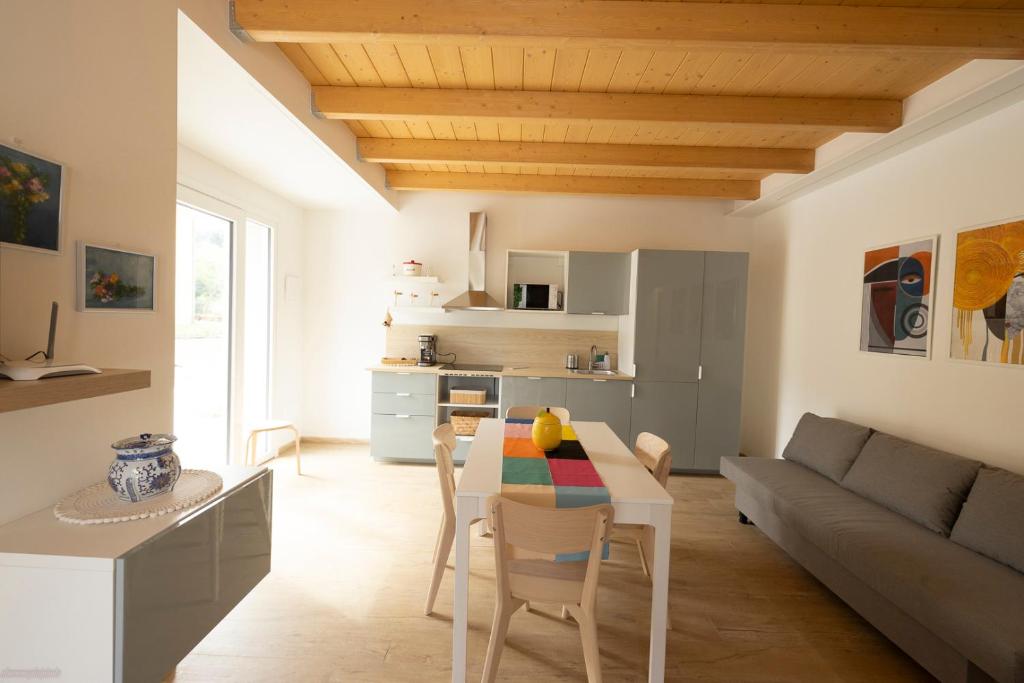 a kitchen and living room with a table and a couch at La casa nel verde in Recanati