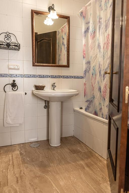 W łazience znajduje się umywalka, lustro i prysznic. w obiekcie Hotel Las Rosas w mieście Priego de Córdoba