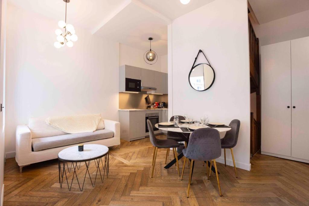 un salon avec une table, des chaises et un canapé dans l'établissement DUPLEX AU COEUR DU 16 Eme, à Paris