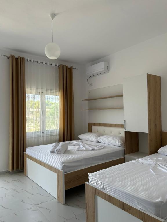 a bedroom with two beds and a window at Vila Roan in Vlorë