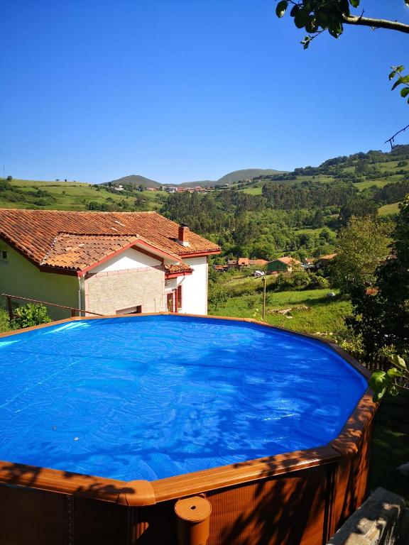 a large blue swimming pool in front of a house at Ohana Campo in Illas