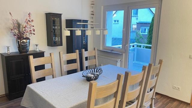 Un comedor con mesa y sillas y una ventana. en LeoMi Ferienwohnung, en Hagen