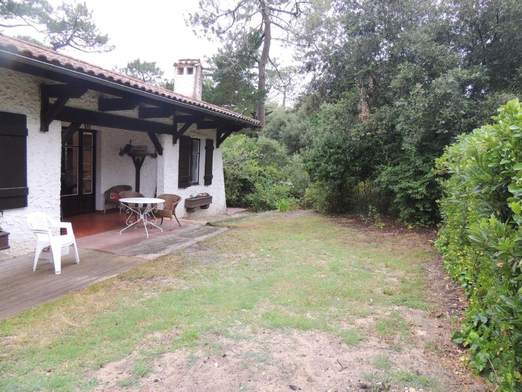 une terrasse avec une table et des chaises dans une maison dans l'établissement villa le mouleau, à La Teste-de-Buch