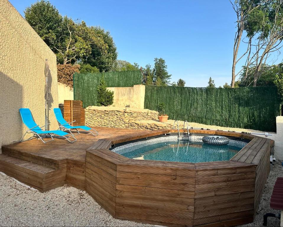 un bain à remous dans une terrasse avec 2 chaises dans l'établissement Maison avec piscine privé eyguieres, à Eyguières