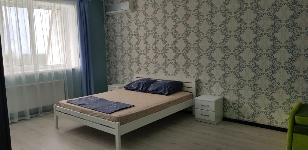 a bedroom with a bed with blue pillows on it at Apartment on Parkovaya in Chornomorsk