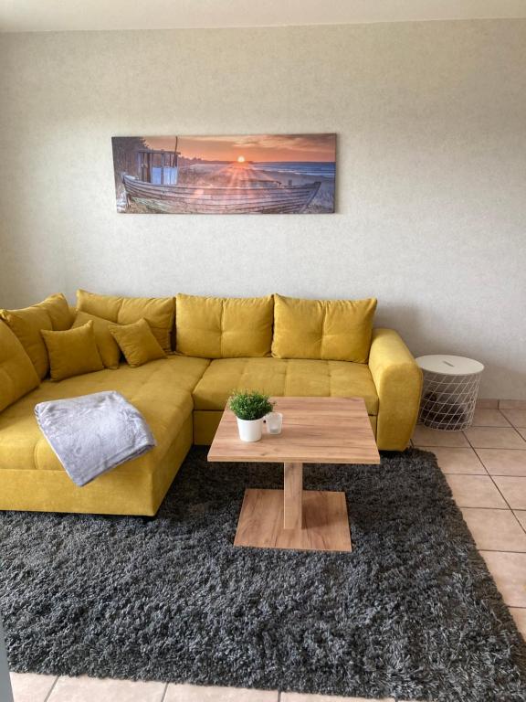 a yellow couch in a living room with a coffee table at Ferienwohnung - Monteurwohnung Büren in Büren