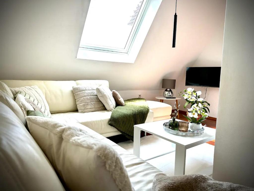 a living room with a white couch and a table at Pures Wohlfühlen mit privater Sauna & Garten in Meschede