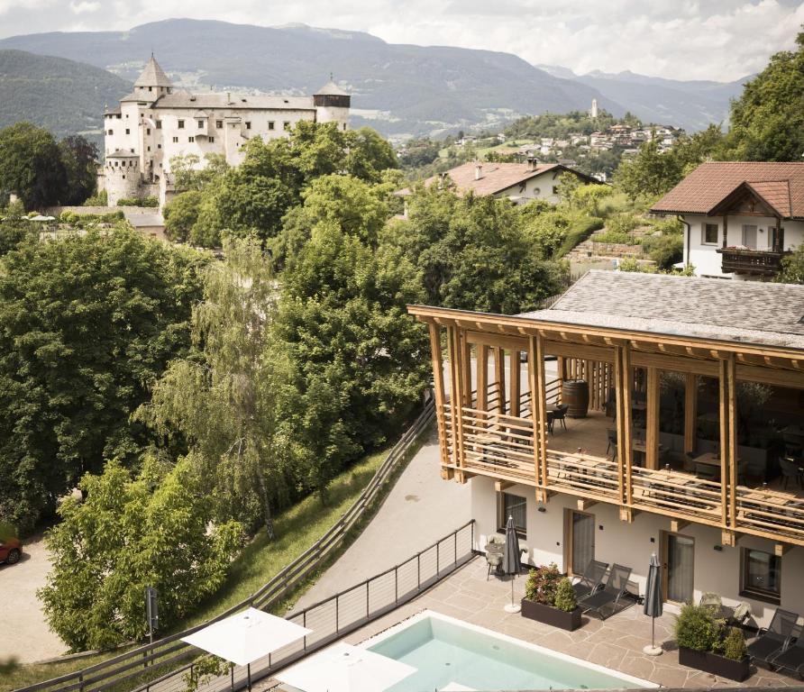 a villa with a view of a building and a pool at Presulis Hideaway Apartments & Restaurant in Fi&egrave;