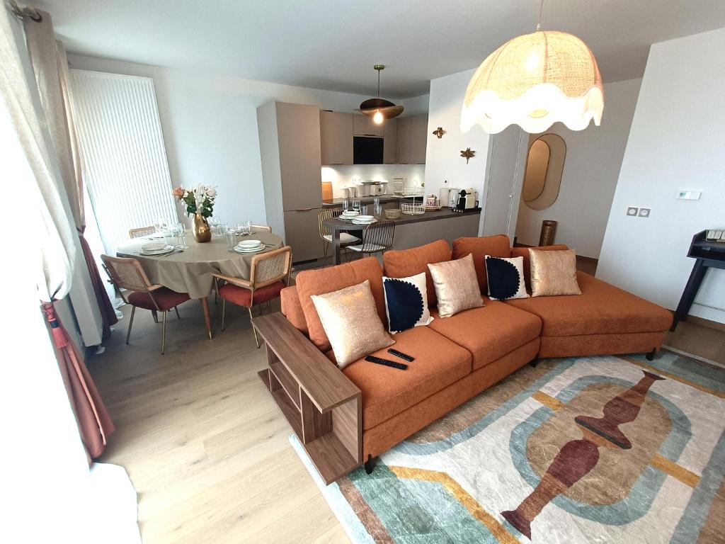 un salon avec un canapé et une table dans l'établissement Disney T3 LUXE neuf 6P 2 ch 2 salle de bain parking privé en sous sol lit bébé C105, à Chessy