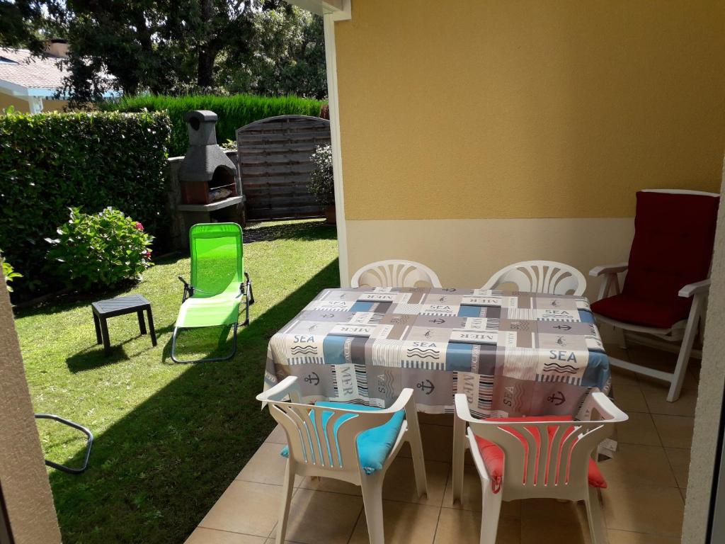 un patio avec une table et des chaises dans une cour dans l'établissement Le coin paisible, à Gujan-Mestras