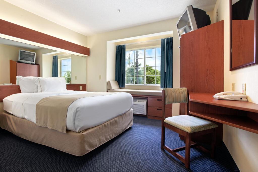 a hotel room with a large bed and a desk at Rincon Inn and Suites in Rincon