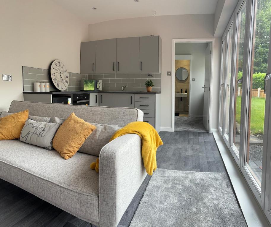 a living room with a couch and a kitchen at Goldie's Retreat in Blackrod