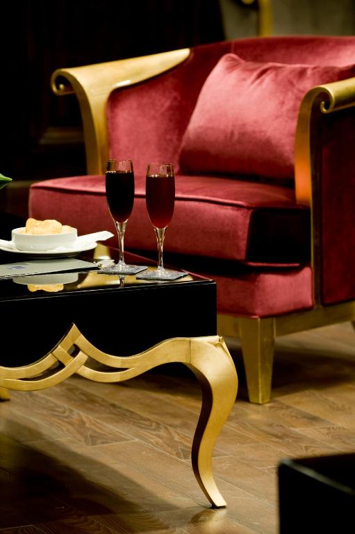 two glasses of red wine on a table next to a couch at Barceló Cairo Pyramids in Cairo