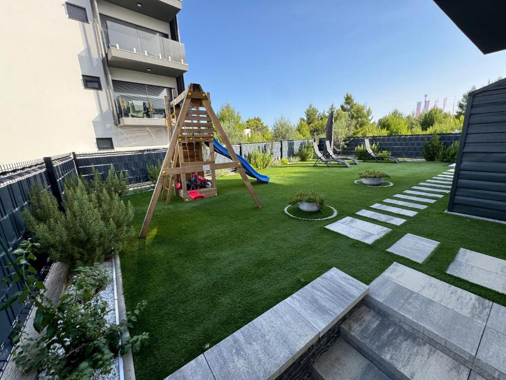 a small backyard with a playground with a slide at 7 Kings Crib in Nin