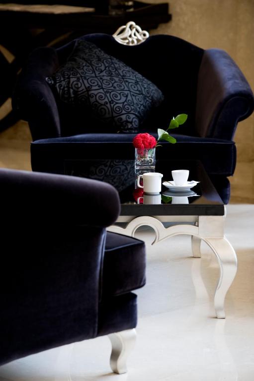 a living room with a black chair and a coffee table at Barceló Cairo Pyramids in Cairo
