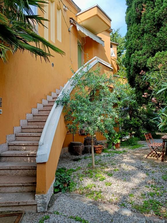 schody prowadzące do budynku z drzewem w obiekcie Casa Lucy w mieście Bardolino