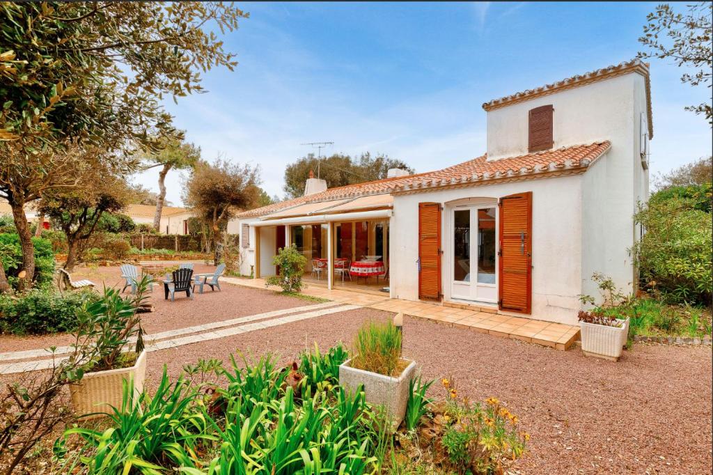 Cette maison blanche dispose d'une terrasse et d'un jardin. dans l'établissement Maison 3 chambres 200m de la mer, à La Pironnière