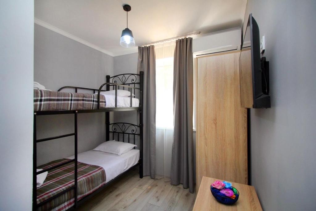 a small room with two bunk beds and a table at KazNest apart-hotel in Almaty