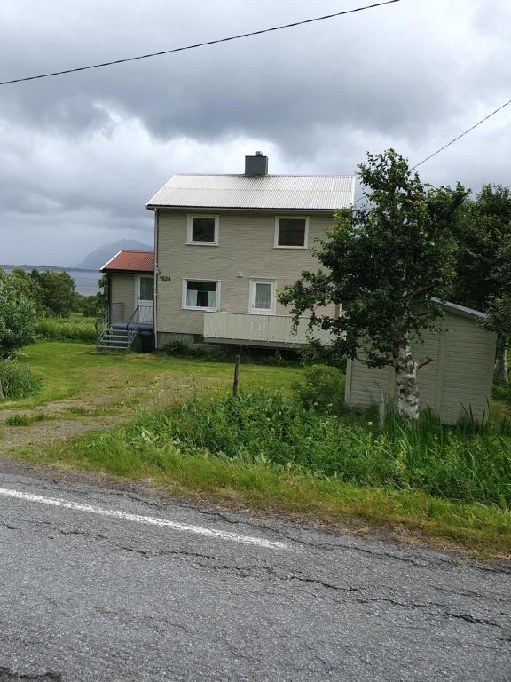 a house sitting on the side of a road at Feriehus med utsikt mot fjellet Hoven in Smedvik