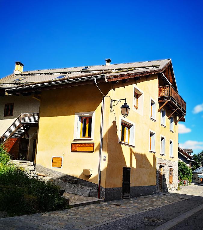 un bâtiment jaune avec une ombre sur son côté dans l'établissement Appartement GENEPI 1350, à Saint-Chaffrey