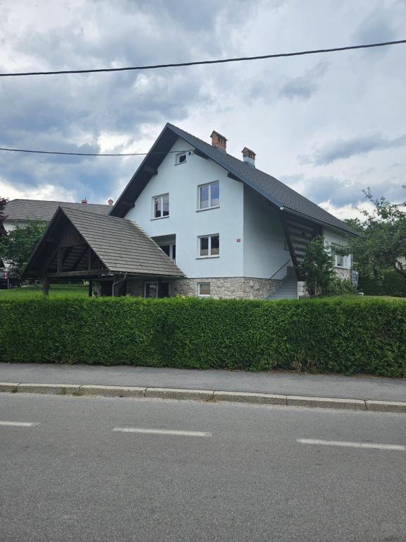 une maison blanche sur le côté d'une rue dans l'établissement Apartments Zalar Bled, à Bled