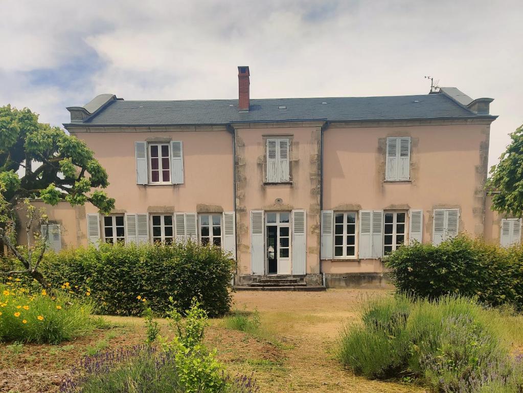 une maison ancienne avec des fenêtres blanches et un toit dans l'établissement Loue belle demeure dans une grande propriété - 16 couchages, 8 chambres, 320 m2 - 30 min de Vichy, à Châtel-Montagne