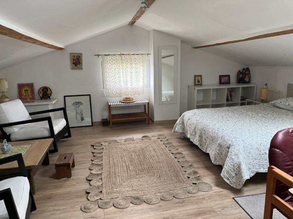 une chambre avec un lit, une chaise et une table dans l'établissement Au dessus du château, à Foix