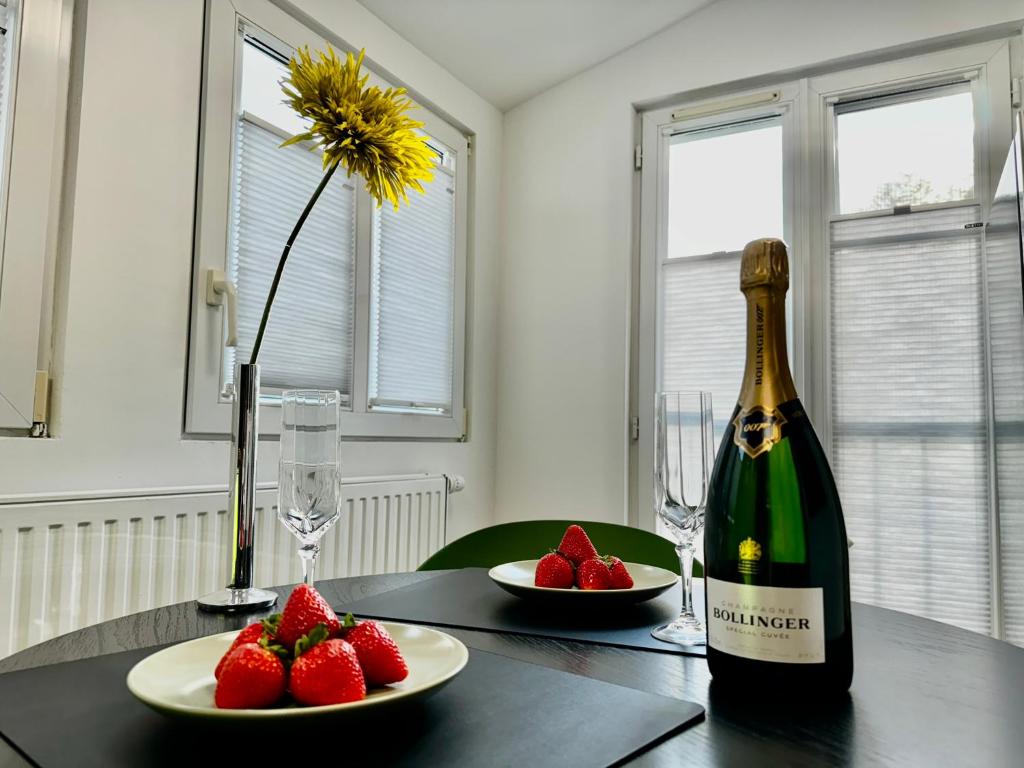 a bottle of wine and strawberries on a table at Big-Kurstadtapartment Baden-Baden in Baden-Baden