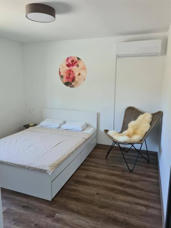 sypialnia z łóżkiem i krzesłem w obiekcie Rooms and apartments Vili w Ptuju