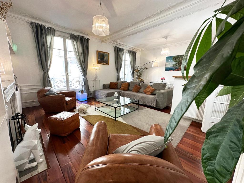 un salon avec un canapé et une table dans l'établissement Appartement spacieux Arc de Triomphe Paris, à Paris