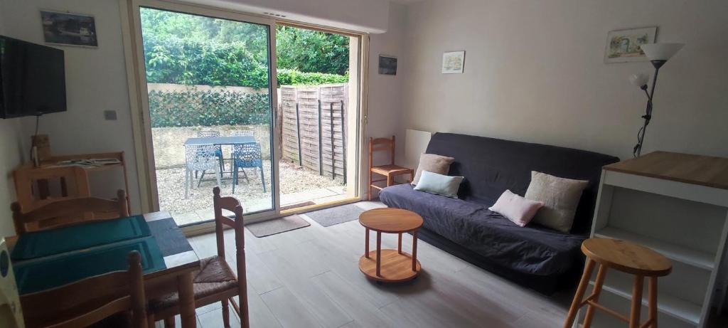 un salon avec un canapé et une table dans l'établissement Appartement 2 pièces de plein pied au coeur du village a deux pas de la plage avec extérieur et parking prive, à Saint-Georges-de-Didonne