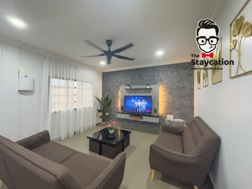 クチンにあるStaycation Homestay 51 Luxe Garden Homestayのリビングルーム(ソファ2台、薄型テレビ付)